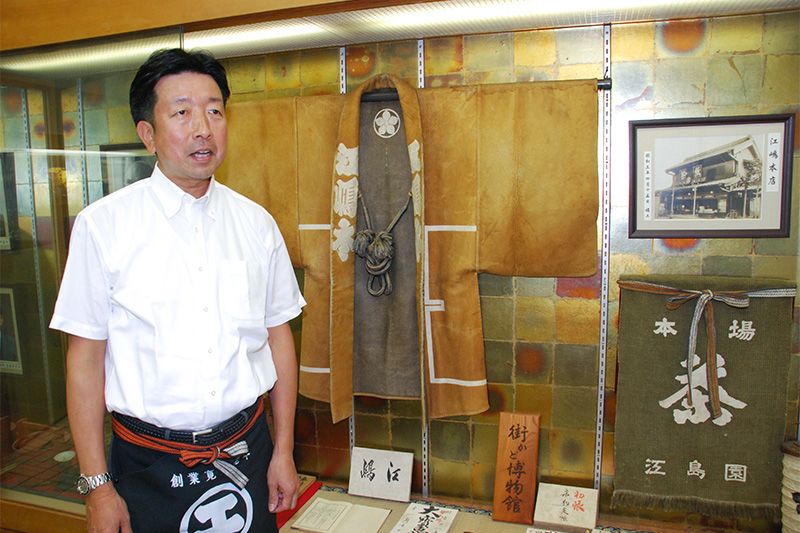 Едзіма Кен, 17-й глава компанії, що має 350-річну історію, перед вітриною з експонатами в магазині «Едзіма»