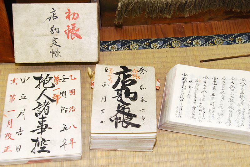 У вітрині з історичними експонатами представлені облікові книги з кінця періоду Едо до Мейдзі