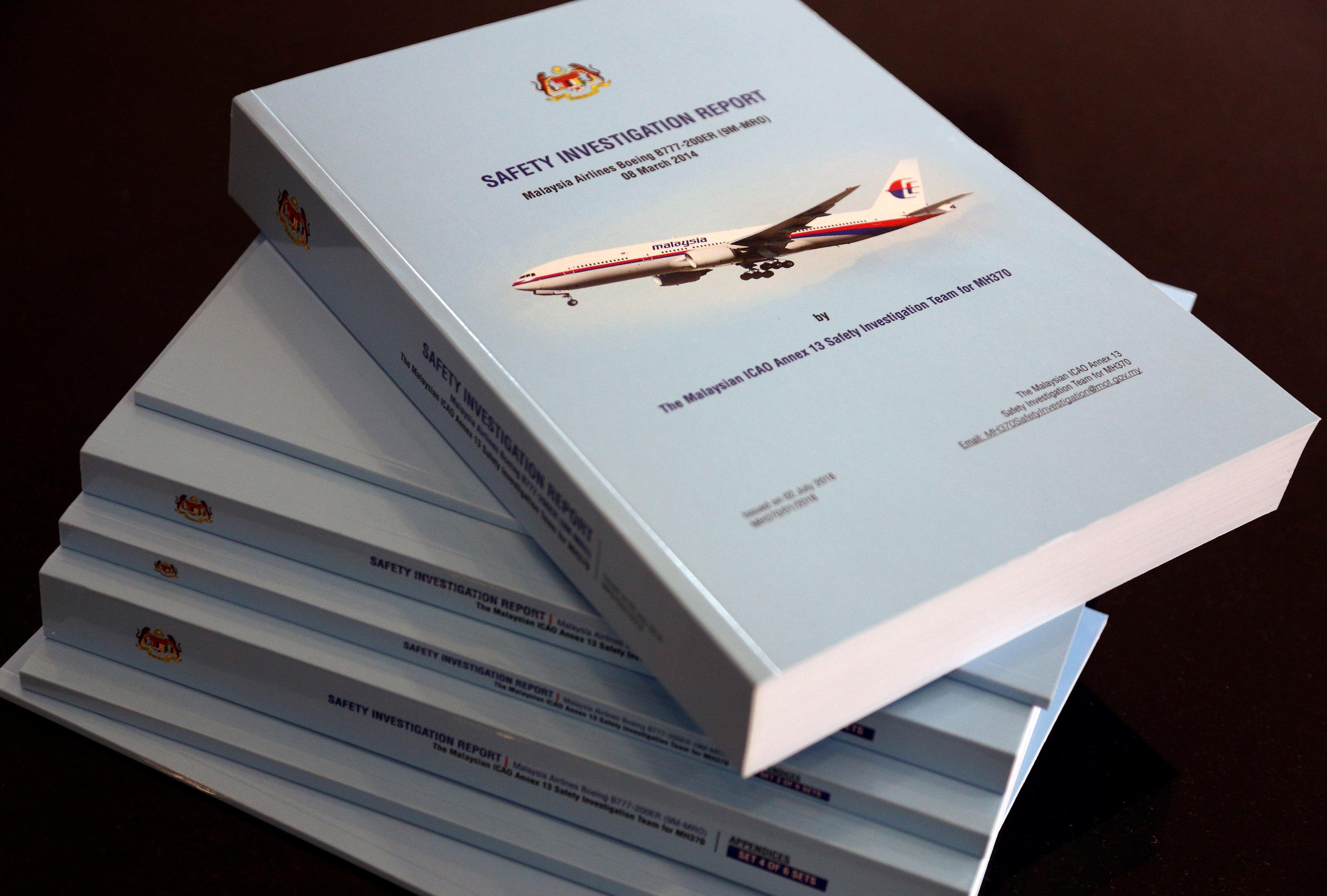 Родственники пассажиров обреченного рейса MH370 плачут, когда они читают отчет о катастрофе
